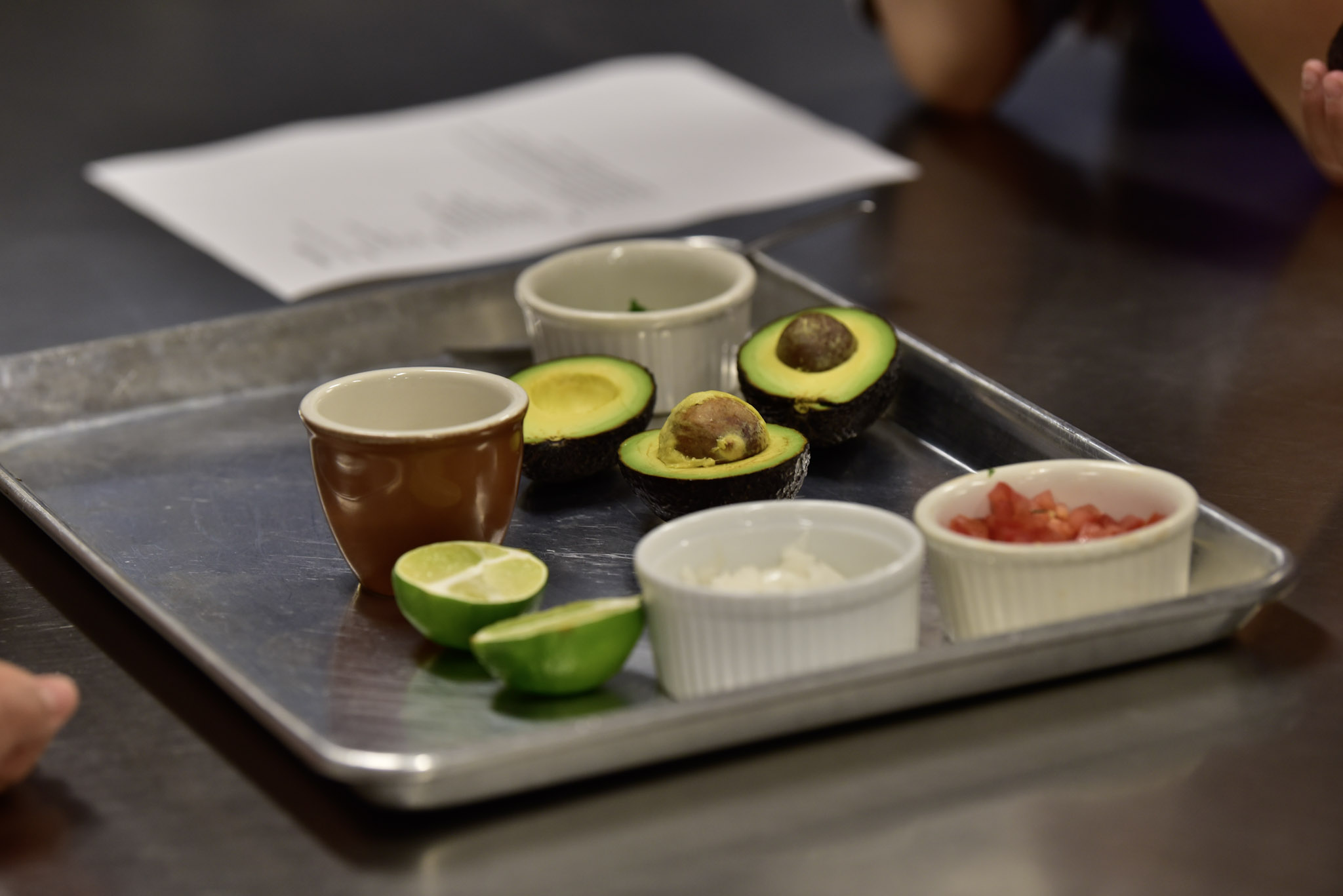 Avocados, lime, and fresh ingredients prepared for a cooking activity